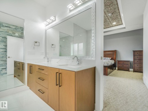 Double vanity featuring wood-finish cabinetry, white countertops, and dual undermount sinks - 3101 Pelerin Crescent, Beaumont, AB 