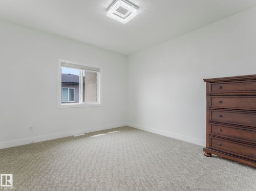 Neutral wall paint complemented by patterned carpeting - 3101 Pelerin Crescent, Beaumont, AB 