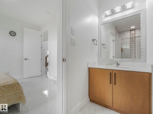 Bathroom vanity featuring a light wood-finish cabinet with double doors, a white countertop, and an integrated sink with a chrome faucet - 3101 Pelerin Crescent, Beaumont, AB 
