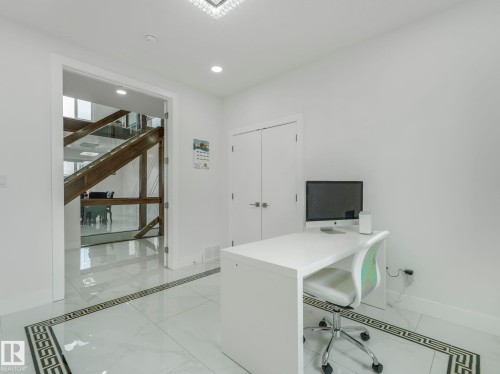 Light-filled room featuring polished tile flooring with a decorative border, recessed lighting, and a modern chandelier - 3101 Pelerin Crescent, Beaumont, AB 