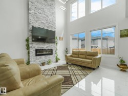 Living space featuring a full-height stone-clad fireplace with an integrated linear electric fireplace - 
