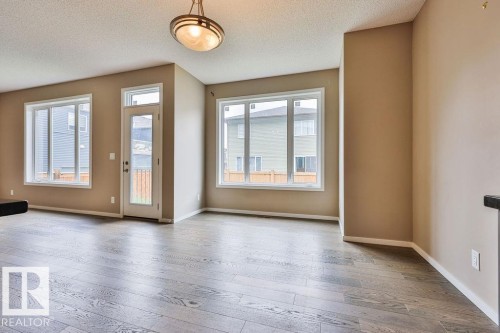 Spacious room with dark wood-finish flooring, neutral wall paint, and white trim - 2031 207 Street, Edmonton, AB 