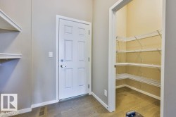 Functional entryway featuring a paneled door, wood-finish flooring, and built-in shelving - 