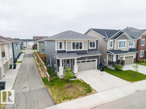 Contemporary two-story residence featuring a two-car garage, concrete driveway, and a small front lawn - 2031 207 Street, Edmonton, AB 