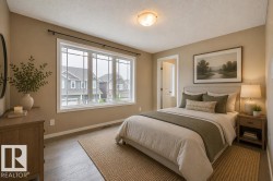 Spacious room featuring wood-finish flooring, a large window with mullions, and a flush-mount ceiling light. Virtually Staged Photos - 