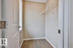 Closet space featuring wood-finish flooring, neutral-toned walls, and a white wire shelving system - 