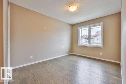 Hardwood flooring, neutral wall paint, and a multi-pane window - 2031 207 Street, Edmonton, AB 