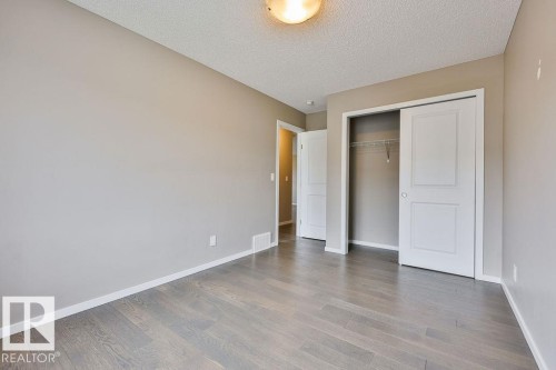 Room featuring wood-finish flooring, neutral wall paint, and white baseboards - 2031 207 Street, Edmonton, AB 