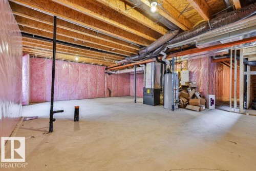 Unfinished basement featuring exposed wood joists, concrete flooring, insulated walls, and visible utility systems - 2031 207 Street, Edmonton, AB 