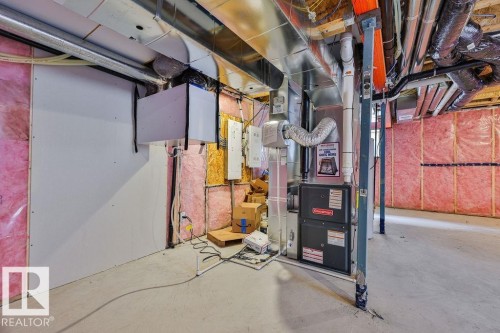 Unfinished basement space featuring exposed utility lines, insulation-lined walls, a concrete floor, and visible structural supports. Side Separate Entrance For Future Self-Contained Suite Potential. - 2031 207 Street, Edmonton, AB 