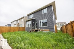 Contemporary two-story residence featuring dark horizontal siding and a light soffit - 
