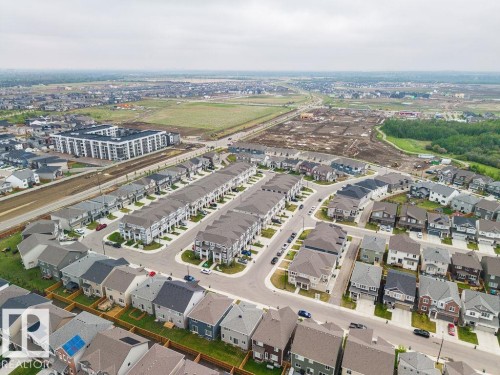 Aerial perspective showcasing a modern residential community with a mix of detached homes and attached townhomes - 2031 207 Street, Edmonton, AB 