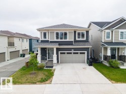 Contemporary two-story residence featuring a dark gray and light gray facade with white trim - 