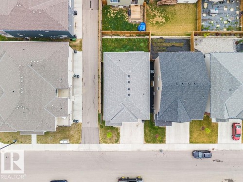 Residential property featuring a grey shingle roof, concrete driveway, and front lawn - 2031 207 Street, Edmonton, AB 