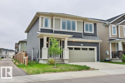 Two-story residence featuring a two-tone facade, an integrated garage, and a covered front entry with columns - 2031 207 Street, Edmonton, AB 