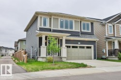 Two-story residence featuring a two-tone facade, an integrated garage, and a covered front entry with columns - 