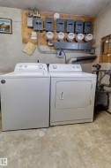 Dedicated utility area featuring a washer and dryer, multiple electrical panels, and utility meters - 