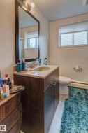 Bathroom vanity with a granite countertop, undermount sink, and wood-finish cabinetry - 
