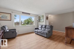 Living area featuring light wood-finish flooring and a large picture window - 