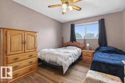 Neutral-toned walls complement wood-finish flooring in this room featuring a ceiling fan - 