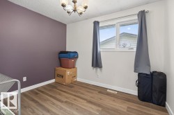 Spacious room featuring wood-finish flooring, a window offering natural light, and a ceiling-mounted light fixture - 