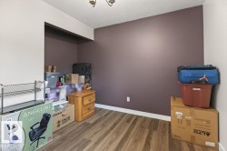Room featuring wood-finish flooring, a ceiling fixture, and a recessed wall area - 