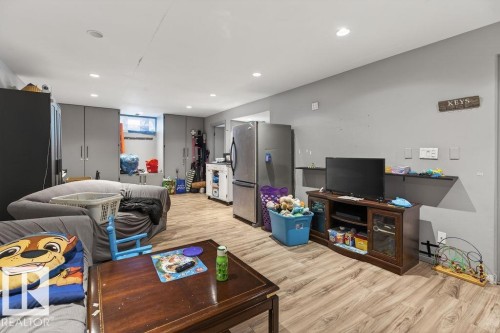 Spacious interior room featuring wood-finish flooring, recessed lighting, and a neutral wall color - 123 Grandin Drive, Morinville, AB 