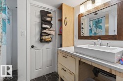 Bathroom vanity featuring a rectangular vessel sink, dual-handle faucet, and wood-framed mirror - 