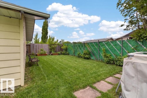 Manicured lawn with stepping stone pathway and raised garden beds - 123 Grandin Drive, Morinville, AB 