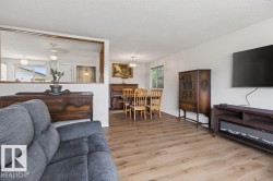 Open-concept living area featuring wood-finish flooring throughout - 