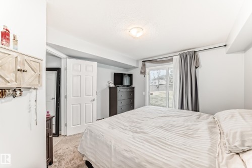 Bedroom featuring light-toned carpeting and neutral wall paint - 53 150 Edwards Drive, Edmonton, AB 