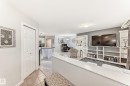 Open-concept living area featuring a built-in media center with extensive shelving, light gray wall paint, and recessed lighting - 53 150 Edwards Drive, Edmonton, AB 