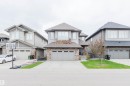 Two-story residential architecture featuring a stone and siding exterior - 1957 Ainslie Link, Edmonton, AB 