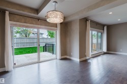 Expansive living space featuring wood-finish flooring, recessed lighting, and a decorative drum pendant light - 