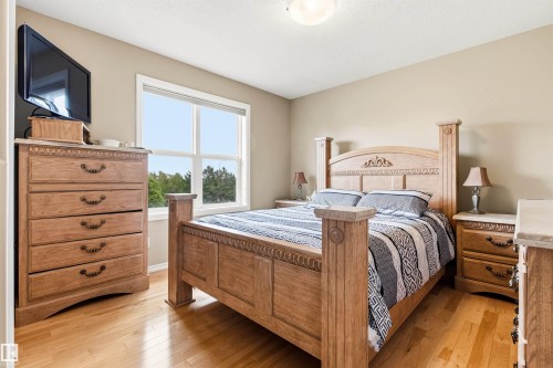 Bright bedroom featuring hardwood flooring and neutral wall tones - 32 Lamplight Bay, Spruce Grove, AB 