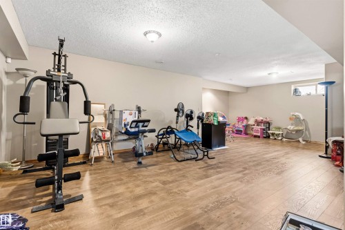 Spacious lower level featuring wood-finish flooring, neutral wall tones, recessed lighting, and a drop ceiling - 32 Lamplight Bay, Spruce Grove, AB 