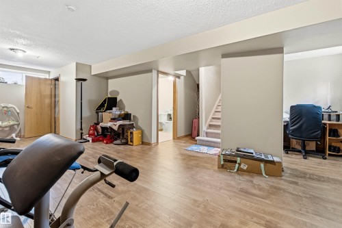 Spacious lower level featuring wood-finish flooring, light-toned walls, and a recessed window - 32 Lamplight Bay, Spruce Grove, AB 