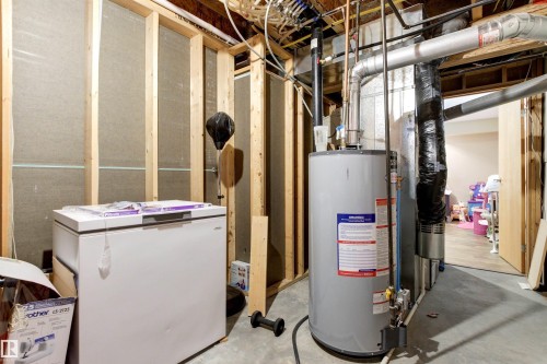 Unfinished basement area with exposed wooden framing and partial insulation - 32 Lamplight Bay, Spruce Grove, AB 