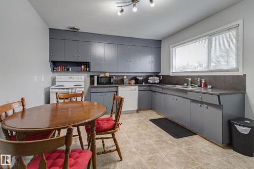 Kitchen featuring extensive gray cabinetry with chrome hardware, ample counter space, a double basin sink, and tile flooring - 10524 78 Street, Edmonton, AB - Indoor