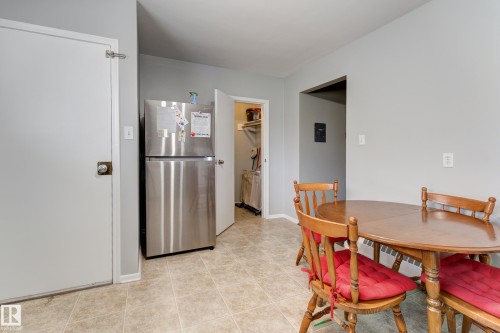 Kitchen space featuring neutral-toned tile flooring, light gray wall paint, and a stainless steel refrigerator - 10524 78 Street, Edmonton, AB - Indoor Photo Showing Dining Room