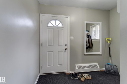 Entryway featuring a paneled door with an arched transom window, light gray walls, and dark flooring - 10524 78 Street, Edmonton, AB - Indoor Photo Showing Other Room