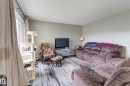 Spacious living area featuring light gray wall paint, white trim, and a window with neutral drapes - 10524 78 Street, Edmonton, AB  - Indoor Photo Showing Living Room 