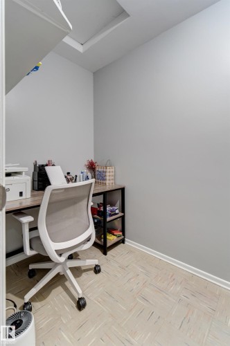 Dedicated office area featuring light gray walls, patterned flooring, and a built-in desk with shelving - 10524 78 Street, Edmonton, AB - Indoor Photo Showing Office