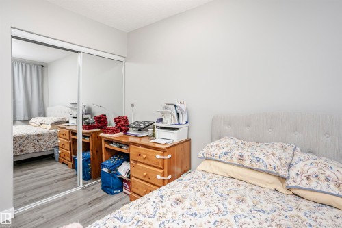 Mirrored closet doors providing expansive reflection, set against light gray walls and wood-finish flooring - 3103 109 Street, Edmonton, AB 