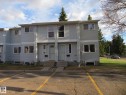 Multi-unit property featuring light-gray horizontal siding, white trim windows, and two distinct entrances with white screen doors - 3103 109 Street, Edmonton, AB 