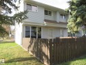 Two-story property featuring light-colored siding, a brown shingle roof, and multiple windows - 3103 109 Street, Edmonton, AB 