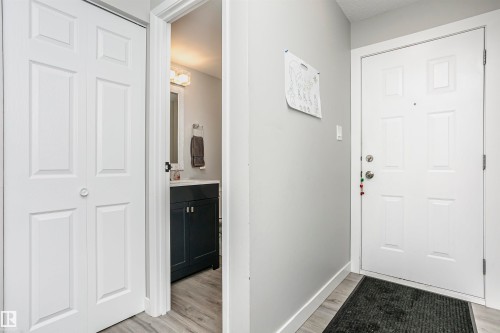Entryway featuring a panel door, light gray wall tones, and wood-finish flooring - 3103 109 Street, Edmonton, AB 