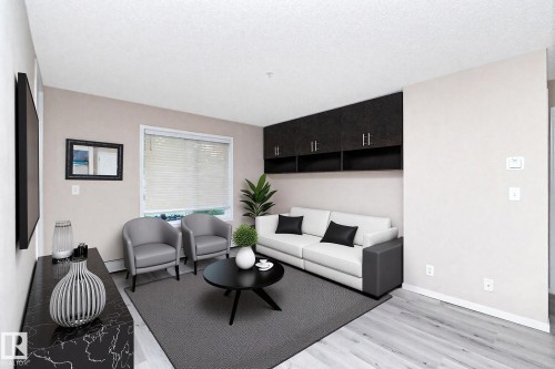 Living area featuring light wood-finish flooring, neutral wall tones, and built-in dark cabinetry with open shelving - 108 530 Watt Boulevard, Edmonton, AB 