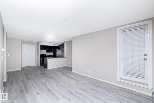 Spacious living area featuring light wood-finish flooring and neutral wall tones - 108 530 Watt Boulevard, Edmonton, AB 