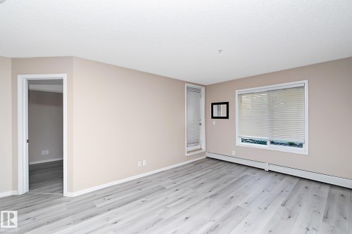 Light-toned walls with contrasting white trim, featuring wood-finish flooring - 108 530 Watt Boulevard, Edmonton, AB 